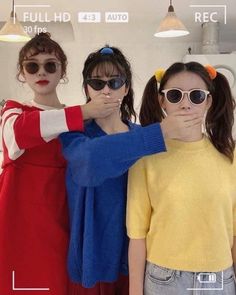 three young women standing next to each other with their hands on their hipss and looking at the camera