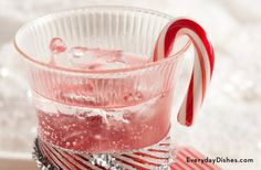 a candy cane sticking out of the top of a glass filled with ice and water