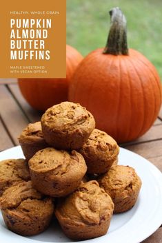 a white plate topped with muffins on top of a wooden table next to pumpkins