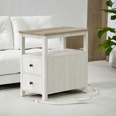 a living room with a white couch and wooden table next to it on the floor