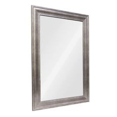 a silver framed mirror on a white wall