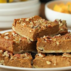 a white plate topped with brownies covered in nuts