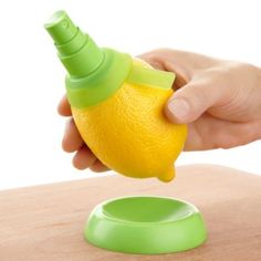 a hand is squeezing an orange into a container