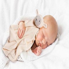 a baby is sleeping on a white blanket