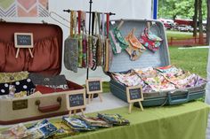 an open suitcase sitting on top of a green table next to other luggage and bags