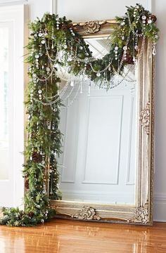 a mirror sitting on top of a hard wood floor next to a wall covered in christmas decorations