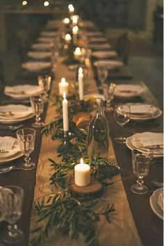 a long table is set with candles and place settings for the dinner guests to enjoy