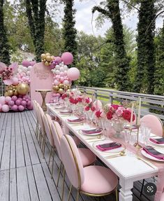 a table set up with pink and gold balloons