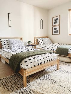 two beds in a room with white walls and black and white patterned bedding on them