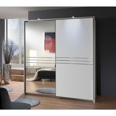 an image of a modern bedroom setting with mirrored closet doors in white and black color