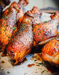 several pieces of chicken on a plate with seasoning