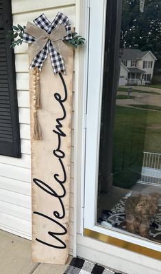 a wooden sign that says welcome on the front porch