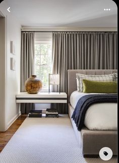 a bed room with a neatly made bed next to a window and a rug on the floor