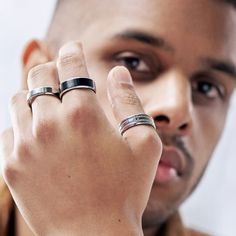 a close up of a person wearing two rings on his finger and another ring in the other hand