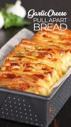 garlic cheese pull apart bread in a pan on a wooden table with text overlay that reads garlic cheese pull apart bread