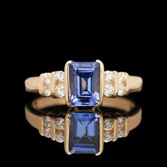 an engagement ring with a blue sapphire and diamond accents on the band, set in yellow gold