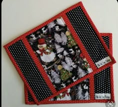 three placemats with black and white polka dots on them, decorated with christmas trees and snowmen