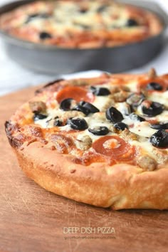 two pizzas sitting on top of a wooden cutting board next to eachother