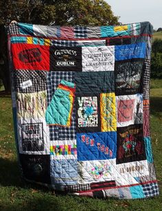 a quilt is hanging on the grass outside