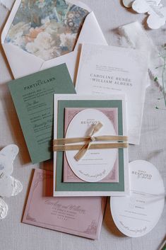 the wedding stationery is laid out on top of each other, including cards and envelopes