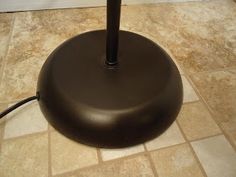 a black umbrella sitting on top of a brown floor next to a white toilet paper roll