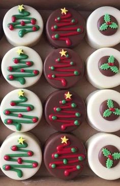 twelve decorated cupcakes in a box with christmas trees and stars on the top