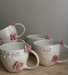 four white coffee cups with pink butterflies on them