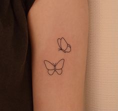 a woman's arm with two butterfly tattoos on the left side of her arm