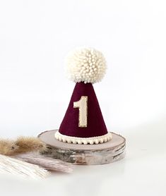 Burgundy party hat is made of -burgundy felt -beige Pom and pompom trim -elastic band - beige number with gold background Size is  H 12 cm W 8 cm Please make sure the size meets your expectations before purchasing This cutie is perfect for your little ones birthday cake smash, photoshoot and more... IMPORTANT: Please do not give it to the baby or kids to play with. It can cause choking due to small particles or decorations. So please take that granted. THANK YOU Kindly note: Make sure your addre Birthday Cake Smash Photoshoot, Burgundy Party, Cake Smash Photoshoot, Smash Photoshoot, 1st Birthday Hats, Hat Cake, Birthday Cake Smash, Birthday Hat, Gold Background