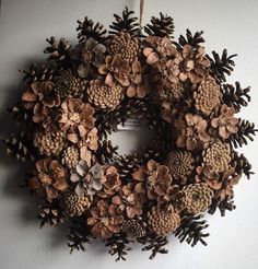 a wreath made out of pine cones hangs on the wall