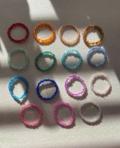 several different colored bracelets sitting on top of a white table next to each other