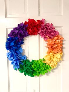 a rainbow colored wreath hanging on the front door