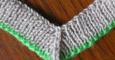 a close up of a knitted object on a wooden table with yarn in the shape of a heart