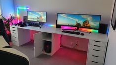 two computer monitors sitting on top of a white desk