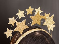 a girl wearing a gold headband with stars on it's side and hair pins in the middle