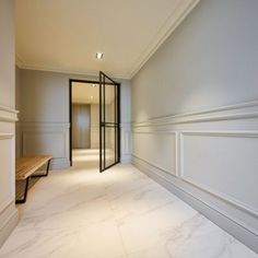 an empty room with white walls and marble flooring