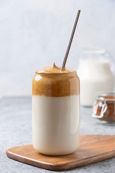 there is a drink in a glass with a straw sticking out of it on a cutting board