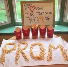 a table topped with fries and cupcakes next to a sign