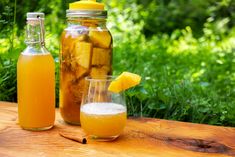 two jars filled with liquid sitting on top of a wooden table