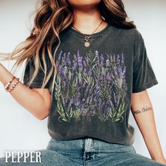 "Oversized Vintage Botanical Wild Flower Tee, our Vintage Pressed Flower Shirt, a tribute to cozy elegance and wild floral wonders! Picture yourself in the midst of a vintage garden, surrounded by the delicate charm of lupine flowers, immortalized on the soft canvas of this Floral Cottage Core tee. This shirt isn't just for fashion; it's a statement - a declaration of your love for all things floral and a nod to the enchanting world of cottage core. Whether you're gifting it to a garden lover or treating yourself, this Lupine-adorned gem is the perfect addition to any wardrobe. It's more than clothing; it's a piece of art that captures the essence of the great outdoors. Comfort Color C1717- Cottagecore Lavender Purple Flower  Print T shirt Unisex Garment-Dyed shirt  For this Design on a SW Lavender Shirt, Lupine Flowers, Floral Cottage, V Neck Shirts, Cottagecore Shirt, Flower Sweatshirt, Vintage Cottagecore, Granola Girl, Girl Shirt