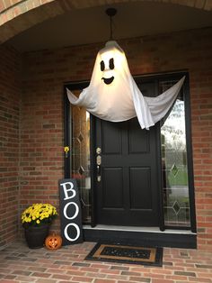 a black door with a ghost hanging from it's side and a boo sign on the front