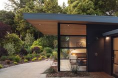 a small black house with glass doors and windows