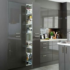 a kitchen filled with lots of gray cabinets and counter top space next to a sink