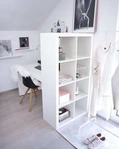 a white bookcase in the corner of a room next to a desk and chair