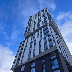 a very tall building with lots of windows on it's side and blue sky in the background