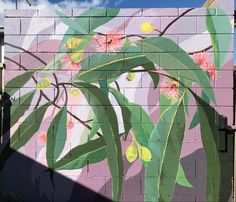 a painted mural on the side of a brick wall with flowers and leaves in it