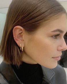 a close up of a person wearing some kind of earring on their left ear