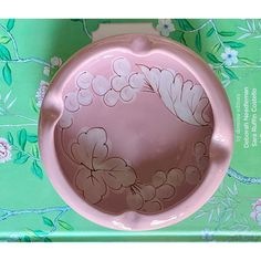 a pink bowl with flowers painted on it