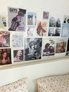 there are many posters on the wall above the bed and in front of the headboard