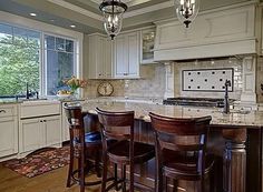 a kitchen with an island and bar stools in front of the countertop area